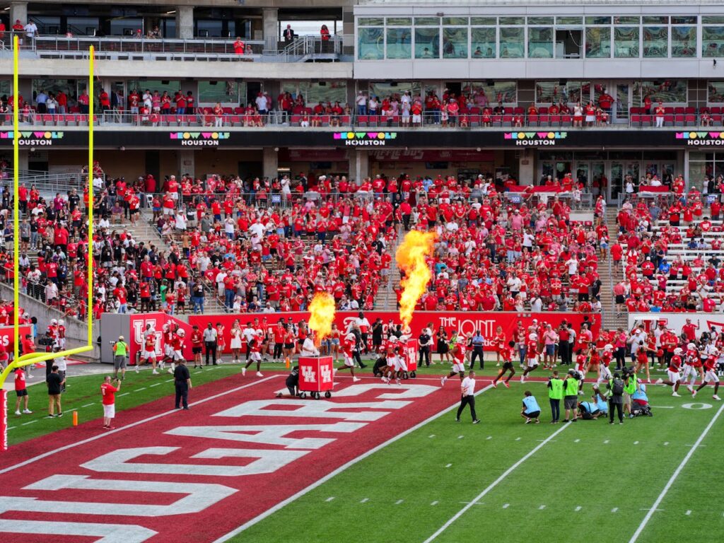 The Art of Drawing Readers In: Your attractive post title goes here Houston college football match with vibrant crowd and fire effects. Captures the sports spirit.